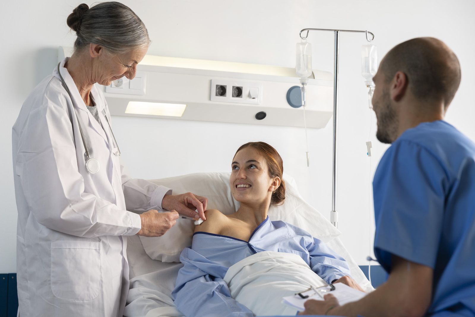Ärztin und Pfleger bei der Betreuung einer Patientin in einem Krankenzimmer